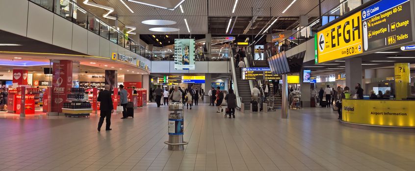 AMSTERDAM SCHIPHOL, THE NETHERLANDS - JUNE 12, 2014: Shopping center Schiphol Plaza at Schiphol airport.

Amsterdam Schiphol, The Netherlands - June 12, 2014: Shopping center Schiphol Plaza at Schiphol airport. People are walking by airport.