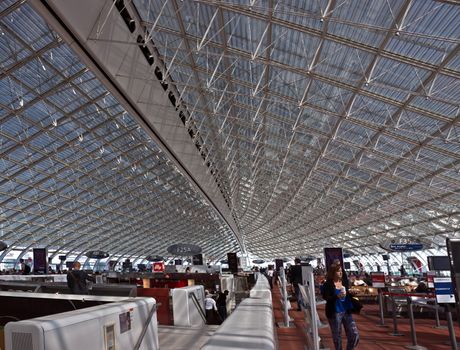 ROISSY, FRANCE - JUNE 12, 2014: Interior view of Charles de Gaulle airport. Airport is one of largest airports in Europe. Named in honor of Charles de Gaulle, President of France. 

Roissy, France - June 12, 2014: Interior view of Charles de Gaulle airport. Airport is one of largest airports in Europe. Named in honor of Charles de Gaulle, President of France. People are walking by airport.