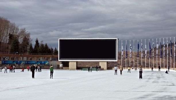 ALMATY, KAZAKHSTAN - NOVEMBER 4, 2014: View of Medeo outdoor stadium. Medeo is located on 1691 meters above sea level. 

Almaty, Kazakhstan - November 4, 2014: View of Medeo outdoor stadium. Medeo is located on 1691 meters above sea level. People are skating.