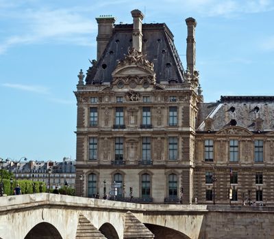 PARIS, FRANCE - JUNE 11, 2014: View of the Louvre. Louvre is one of the biggest Museum in the world, receiving more than 8 million visitors each year.

Paris, France - June 11, 2014: View of the Louvre. Louvre is one of the biggest Museum in the world, receiving more than 8 million visitors each year. People are walking and looking at the sightseeings.