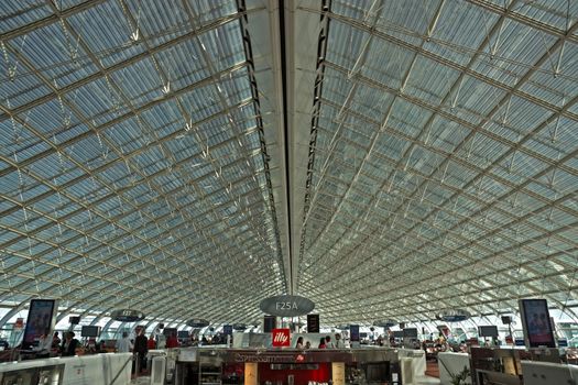 ROISSY, FRANCE - JUNE 12, 2014: Interior view of Charles de Gaulle airport. Airport is one of largest airports in Europe. Named in honor of Charles de Gaulle, President of France. 

Roissy, France - June 12, 2014: Interior view of Charles de Gaulle airport. Airport is one of largest airports in Europe. Named in honor of Charles de Gaulle, President of France. People are standing.