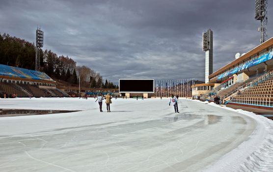 ALMATY, KAZAKHSTAN - NOVEMBER 4, 2014: View of Medeo outdoor stadium. Medeo is located on 1691 meters above sea level. 

Almaty, Kazakhstan - November 4, 2014: View of Medeo outdoor stadium. Medeo is located on 1691 meters above sea level. People are skating.