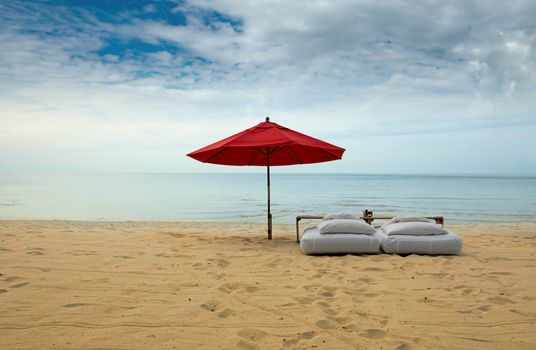 Lonely red umbrella at the tropical beach