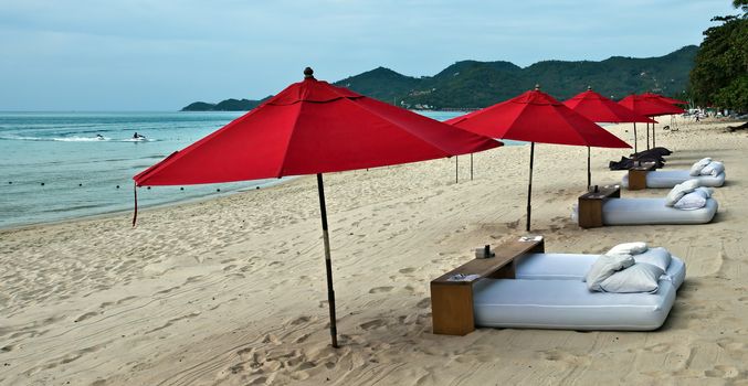 Red umbrellas at the tropical beach, Thailand.