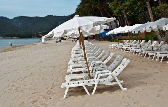 White umbrellas at the tropical beach, Thailand.