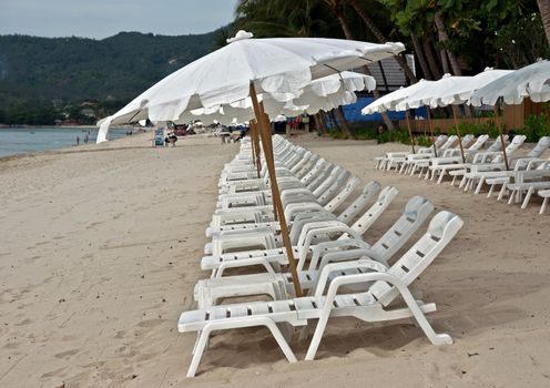 White umbrellas at the tropical beach, Thailand.