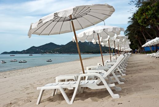 White umbrellas at the tropical beach, Thailand.