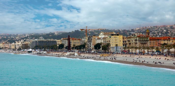 NICE, FRANCE - APRIL 27: Architecture along Promenade des Anglais on April 27, 2013 in Nice, France. It is a symbol of the Cote d'Azur and was built in 1830 at the expense of the British colony.

Nice, France - April 27, 2013: Architecture along Promenade des Anglais. People are resting. Promenade des Anglais is a symbol of the Cote d'Azur and was built in 1830 at the expense of the British colony.