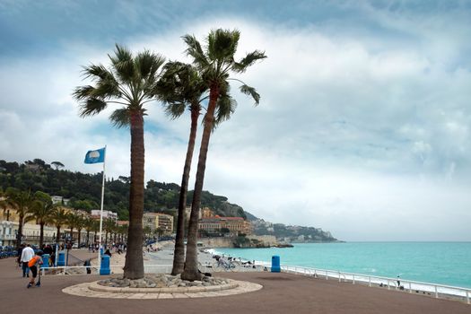 NICE, FRANCE - APRIL 27: Promenade des Anglais on April 27, 2013 in Nice, France. It is a symbol of the Cote d'Azur and was built in 1830 at the expense of the British colony.

Nice, France - April 27, 2013: Promenade des Anglais. People are walking. Promenade des Anglais is a symbol of the Cote d'Azur and was built in 1830 at the expense of the British colony.