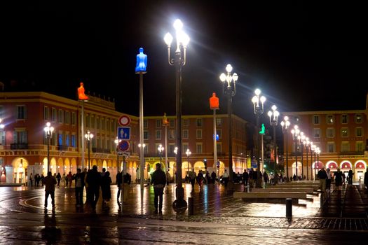 NICE, FRANCE - APRIL 28: The Place Massena at night on April 28, 2013 in Nice, France. The square was reconstructed in 1979. 

Nice, France - April 28, 2013: The Place Massena at night. People are walking. The square was reconstructed in 1979.