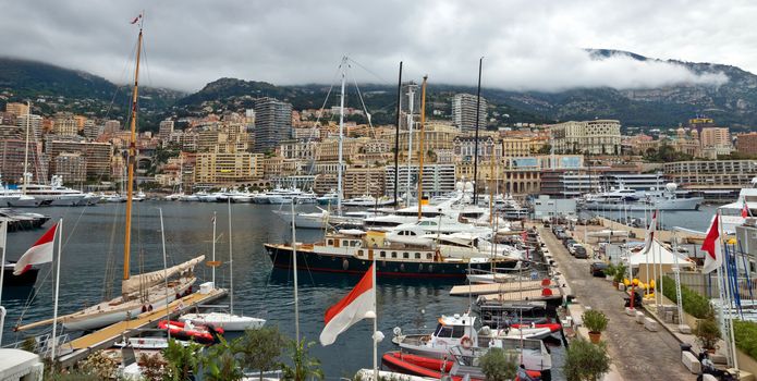 MONTE CARLO, MONACO - APRIL 28: Yachts in the port Hercules and view on the city on April 28, 2013 in Monte Carlo, Monaco. 

Monte Carlo, Monaco - April 28, 2013: Yachts in the port Hercules and view on the city.