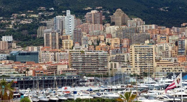 MONTE CARLO, MONACO - APRIL 28: Fashionable yachts in the port Hercules and view on the city on April 28, 2013 in Monte Carlo, Monaco. 

Monte Carlo, Monaco - April 28, 2013: Fashionable yachts in the port Hercules and view on the city.