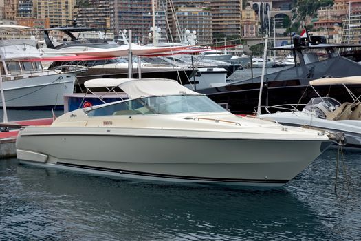 MONTE CARLO, MONACO - APRIL 28: Motor boat in the port Hercules and view on the city on April 28, 2013 in Monte Carlo, Monaco. 

Monte Carlo, Monaco - April 28, 2013: Motor boat in the port Hercules and view on the city.