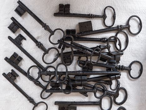 Stack of old keys over cloth background