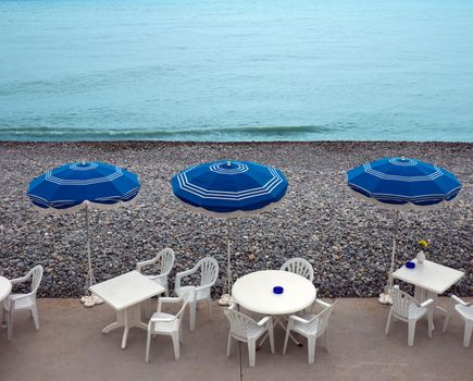 Lounge chairs, tables and parasol on the beach, southern France