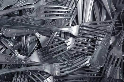 Background of heap old fashioned silver forks.