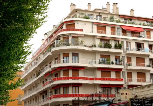 NICE, FRANCE - APRIL 29: Architecture along Promenade des Anglais on April 29, 2013 in Nice, France. It is a symbol of the Cote d'Azur and was built in 1830 at the expense of the British colony.

Nice, France - April 29, 2013: Architecture along Promenade des Anglais. People are resting. Promenade des Anglais is a symbol of the Cote d'Azur and was built in 1830 at the expense of the British colony.