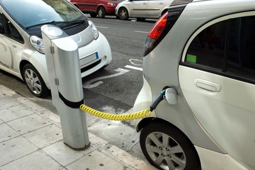Two electric cars charging on a street in the city of Nice.