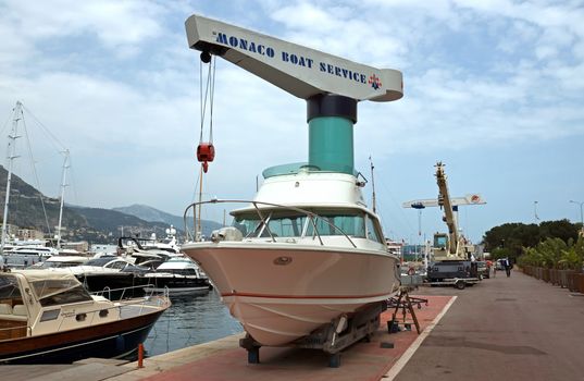 MONTE CARLO, MONACO - MAY 1: Crane lifting boats at the port of Monaco on May 1, 2013 in Monte Carlo, Monaco. 

Monte Carlo, Monaco - May 1, 2013: Crane lifting boats at the port of Monaco.