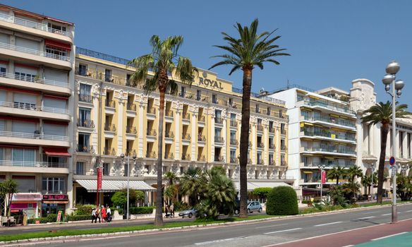 NICE, FRANCE - MAY 2: Architecture along Promenade des Anglais on May 2, 2013 in Nice, France. Promenade des Anglais is a symbol of the Cote d'Azur and was built in 1830 at the expense of the British colony.

Nice, France - May 2, 2013: Architecture along Promenade des Anglais. Promenade des Anglais is a symbol of the Cote d'Azur and was built in 1830 at the expense of the British colony. People walk by street.