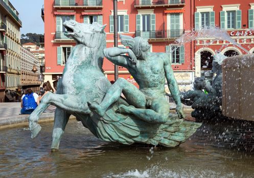 NICE, FRANCE - MAY 2:  Part of Fountain of Soleil on Place Massena on May 2, 2013 in Nice, France. The square was reconstructed in 1979.

Nice, France - May 2, 2013: Part of Fountain of Soleil on Place Massena. Square is located in the city center and is the most popular destination among tourists. The square was reconstructed in 1979. People are resting.