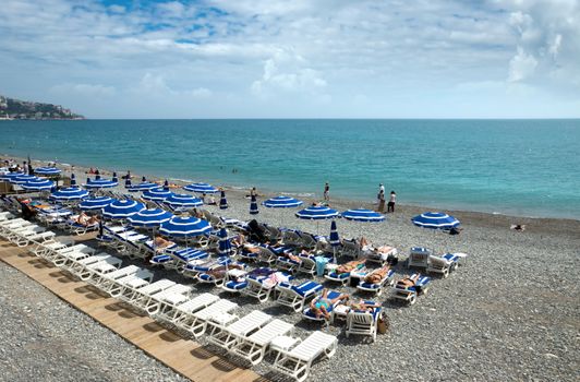 NICE, FRANCE - MAY 2: People on the beach Angel bay on May 2, 2013 in Nice, France. Citizens and tourists are sunbathing enjoying a sunny day on the beach.

Nice, France - May 2, 2013: People on the beach Angel bay. Citizens and tourists are sunbathing enjoying a sunny day on the beach in Angel bay.