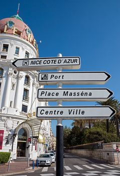 NICE, FRANCE - MAY 4: Road signpost against luxury Hotel Negresco on May 4, 2013 in Nice, France. Hotel Negresco is the famous luxury hotel on the Promenade des Anglais in Nice, a symbol of the Cote d'Azur.

Nice, France - May 4, 2013: Road signpost against luxury Hotel Negresco in Nice, French Riviera. Hotel Negresco is the famous luxury hotel on the Promenade des Anglais in Nice, a symbol of the Cote d'Azur