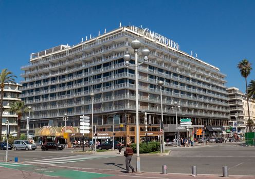 NICE, FRANCE - MAY 4: Hotel Le Meridien is located on the Promenade des Anglais on May 4, 2013 in Nice, France. Hotel Le Meridien is a symbol of the Cote d'Azur. Built in 1974. 

Nice, France - May 4, 2013: Hotel Le Meridien is located on Promenade des Anglais. Hotel Le Meridien is a symbol of the Cote d'Azur. Built in 1974. People are walking.