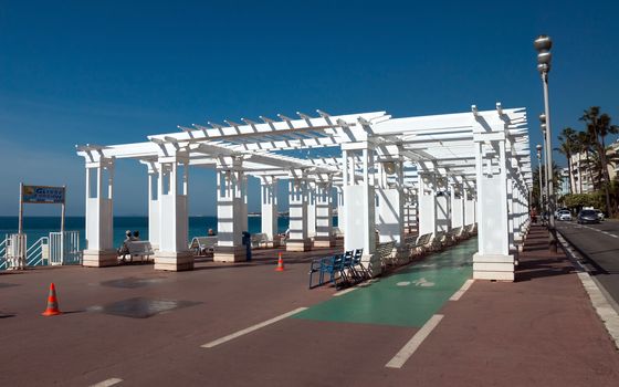 NICE, FRANCE - MAY 4: Pedestrians walking on Promenade des Anglais on May 4, 2013 in Nice, France. It is a symbol of the Cote d'Azur and was built in 1830 at the expense of the British colony.

Nice, France - May 4, 2013: Pedestrians walking on Promenade des Anglais. Promenade des Anglais is a symbol of the Cote d'Azur and was built in 1830 at the expense of the British colony. People are resting.