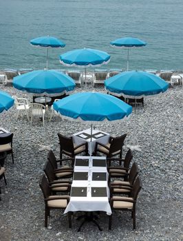 NICE, FRANCE - MAY 5: Beach and cafe with blue umbrellas near Promenade des Anglais on May 5, 2013 in Nice, France. There are many cafes and restaurants along the coast of the Côte d'Azur.

Nice, France - May 5, 2013: Beach and cafe with blue umbrellas near Promenade des Anglais in city of Nice, France. There are many cafes and restaurants along the coast of the Côte d'Azur.