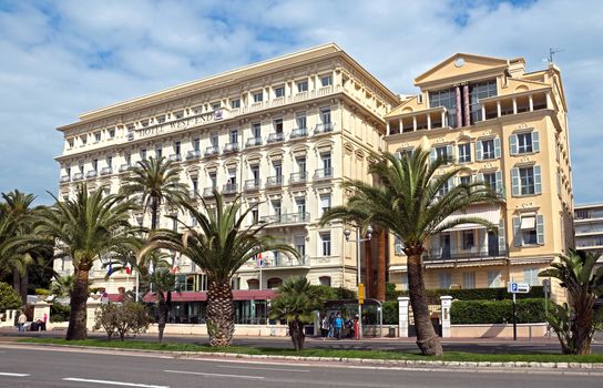 NICE, FRANCE - MAY 5: Architecture along Promenade des Anglais on May, 5, 2013 in Nice, France. It is a symbol of the Cote d'Azur and was built in 1830 at the expense of the British colony.

Nice, France - May 5, 2013: Architecture along Promenade des Anglais. Promenade des Anglais is a symbol of the Cote d'Azur and was built in 1830 at the expense of the British colony. People are standing on the busstop.