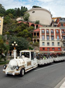 NICE, FRANCE - MAY 5: White trackless train for sightseeing on the Promenade des Anglais on May 5, 2013 in Nice, France. Passengers are listening to the audio guide headphones.

Nice, France - May 05, 2013 : White trackless train for sightseeing on the Promenade des Anglais in Nice. Passengers are listening to the audio guide headphones.