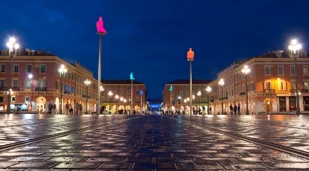 NICE, FRANCE - MAY 6: The Place Massena at night on May 6, 2013 in Nice, France. The square was reconstructed in 1979. 

Nice, France - May 6, 2013: The Place Massena at night. People are walking. The square was reconstructed in 1979.