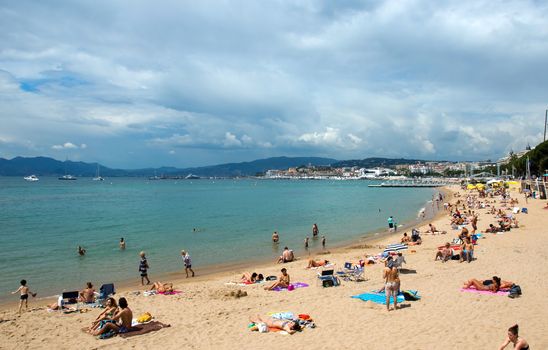 CANNES, FRANCE - MAY 6: People on the most popular beach in Cannes - Plage de la Croisette on May 6, 2013 in Cannes, France. The famous beach on the Croisette, known for its filmfestival in may.

Cannes, France - May 6, 2013: People on the most popular beach in Cannes - Plage de la Croisette. The famous beach on the Croisette, known for its filmfestival in may.
