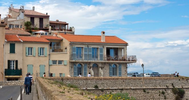ANTIBES, FRANCE - MAY 6: Architecture of old town on May 6, 2013 in Antibes, France. City founded by the Romans in 42 BC.

Antibes, France - May 6, 2013: Architecture of old town in historical centre of Antibes, France. Antibes is a city located in the French Riviera. The city is also famous for its luxury shops, restaurants, and hotels. City founded by the Romans in 42 BC. People are walking by street.