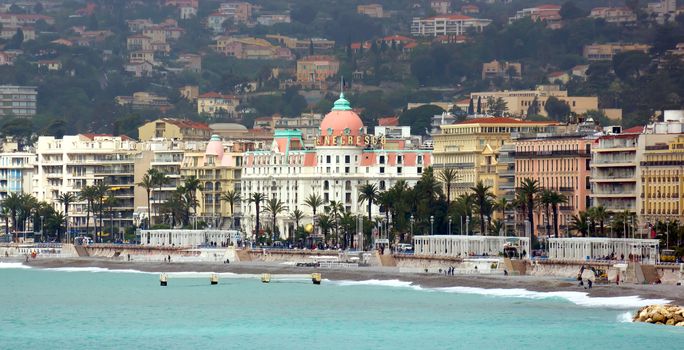 NICE, FRANCE - APRIL 27: Luxury resort of French riviera with view on Hotel Negresco on April 27, 2013 in Nice, France. Hotel Negresco is the famous luxury hotel on the Promenade des Anglais in Nice, a symbol of the Cote d'Azur.

Nice, France - April 27, 2013: Luxury resort of French riviera with view on Hotel Negresco. Hotel Negresco is the famous luxury hotel on the Promenade des Anglais in Nice, a symbol of the Cote d'Azur. People are walking by Promenade.