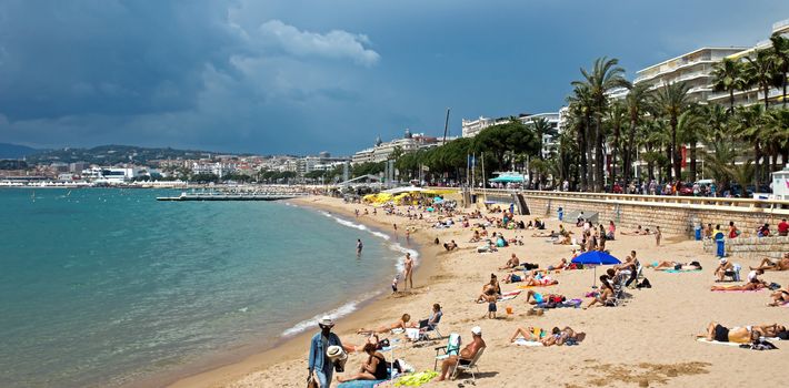 CANNES, FRANCE - MAY 6: People on the most popular beach - Plage de la Croisette on May 6, 2013 in Cannes, France. The famous beach on the Croisette, known for its filmfestival in may.

Cannes, France - May 6, 2013: People on the most popular beach in Cannes - Plage de la Croisette. The famous beach on the Croisette, known for its filmfestival in may. People are sun bathing, swiming and resting