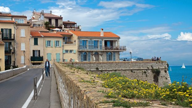 ANTIBES, FRANCE - MAY 6: Cityscape and mediterranean coast on May 6, 2013 in Antibes, France. 

Antibes, France - May 6, 2013: Cityscape and mediterranean coast. Man walks along street.