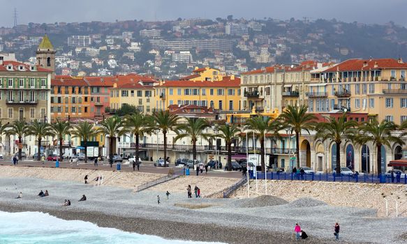 NICE, FRANCE - APRIL 27: Architecture along Promenade des Anglais on April 27, 2013 in Nice, France. It is a symbol of the Cote d'Azur and was built in 1830 at the expense of the British colony.

Nice, France - April 27, 2013: Architecture along Promenade des Anglais. People are resting. Promenade des Anglais is a symbol of the Cote d'Azur and was built in 1830 at the expense of the British colony. People are walking by Promenade and resting on the beach.