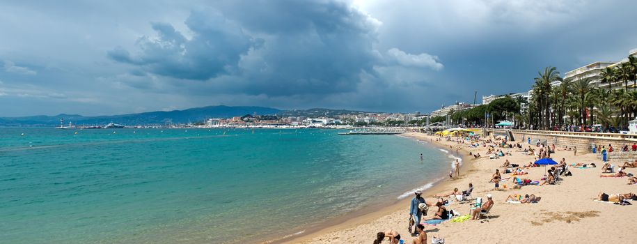 CANNES, FRANCE - MAY 6: People on the most popular beach - Plage de la Croisette on May 6, 2013 in Cannes, France. The famous beach on the Croisette, known for its filmfestival in may.

Cannes, France - May 6, 2013: People on the most popular beach in Cannes - Plage de la Croisette. The famous beach on the Croisette, known for its filmfestival in may. People are sun bathing, swiming and resting