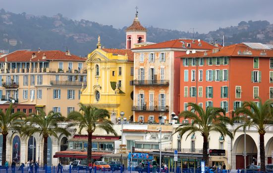 NICE, FRANCE - APRIL 27: Architecture along Promenade des Anglais on April 27, 2013 in Nice, France. It is a symbol of the Cote d'Azur and was built in 1830 at the expense of the British colony.

Nice, France - April 27, 2013: Architecture along Promenade des Anglais. People are resting. Promenade des Anglais is a symbol of the Cote d'Azur and was built in 1830 at the expense of the British colony. People are walking by Promenade.