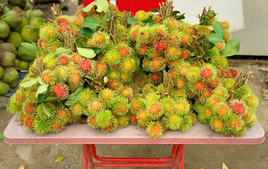 Fresh rambutans sweet delicious fruits at street market