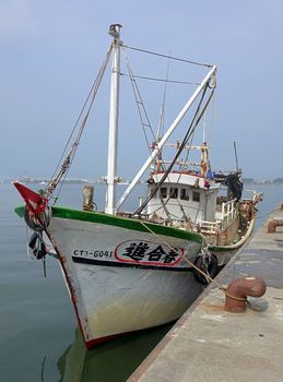 KAOHSIUNG, TAIWAN -- MAY 3, 2014: A local fishing boat returning from a night at sea docks at Sinda Fishing Port.