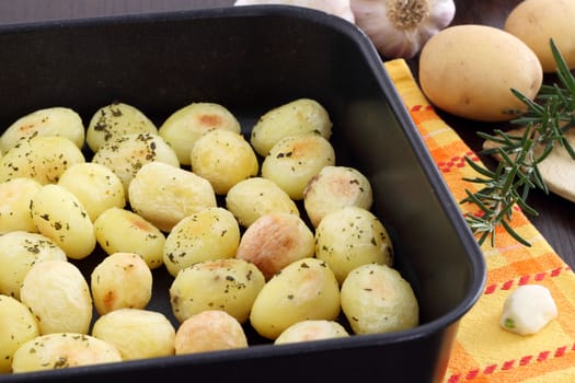 Roasted potatoes in black baking tin