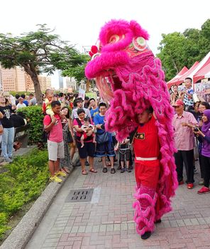 KAOHSIUNG, TAIWAN -- JUNE 20, 2015: Two young men perform a traditional lion dance during the 2015 Dragon Boat Festival activities.