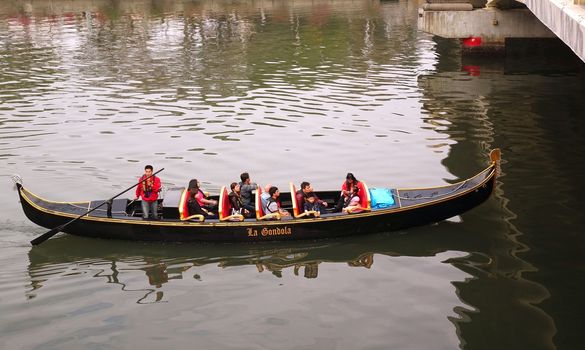 KAOHSIUNG, TAIWAN -- FEBRUARY 22, 2015: Tourists enjoy a ride on the Love River in a boat that resembles a Venetian gondola.
