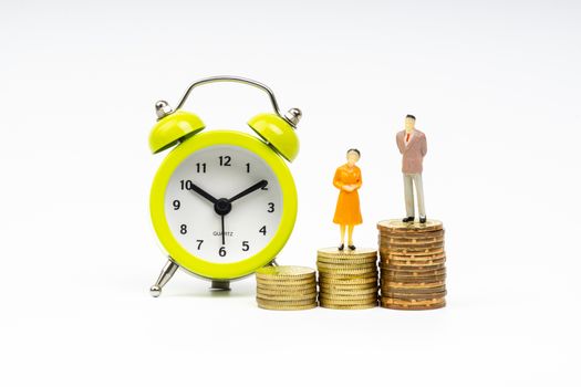 Kuala Lumpur, Malaysia - March 2, 2019 : Alarm Clock and Miniature people standing on stacking coins with white background. Business and Lifestyle concepts.