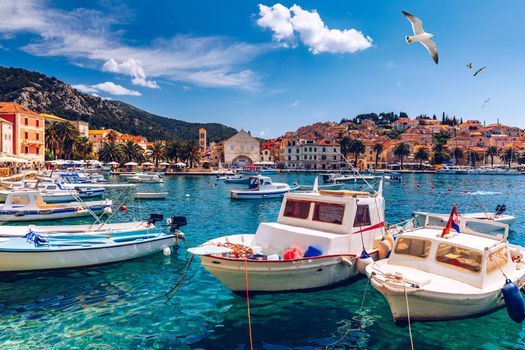 View at amazing archipelago with fishing boats in front of town Hvar, Croatia. Harbor of old Adriatic island town Hvar with seagull's flying over the city. Amazing Hvar city on Hvar island, Croatia. 