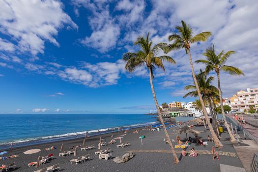 Puerto Naos beach an sunbathing people at beach with black lava sand at La Palma, Canary Island, Spain.