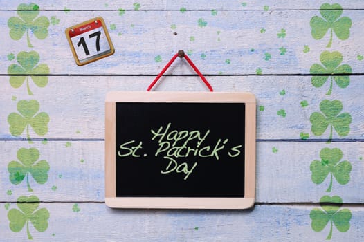 Blackboard hanging on a old wooden wall with St. Patrick«s Day.